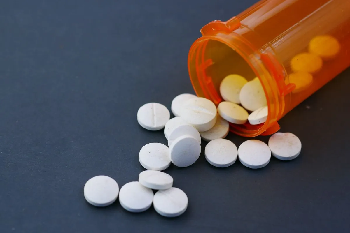 Prescription pills spilling from an open bottle, illustrating that more than 200 everyday medications can be ototoxic and damage hearing