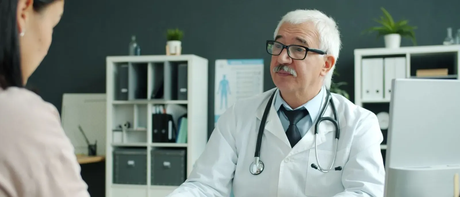 Older patient sitting calmly with an audiologist during a first hearing test consultation in a modern medical office