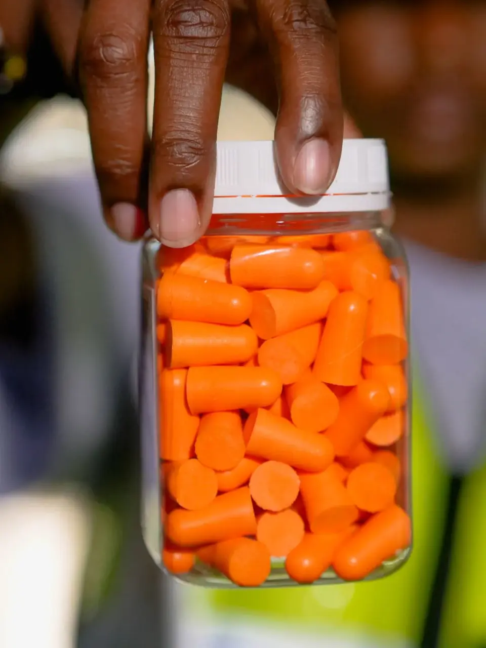 A jar of orange foam earplugs used to prevent noise-induced hearing loss