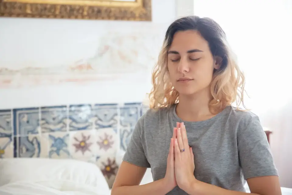 Woman practicing calm breathing and meditation to help manage stress-related tinnitus flare-ups